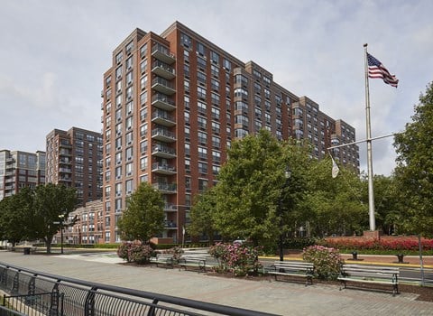 a large apartment building with a american flag in front of it